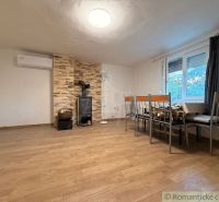 Ein Interieur einer Hütte mit Holzboden, Kamin und Essecke.