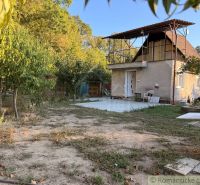 Eine Hütte in Nové Zámky mit Garten und Terrasse, umgeben von Bäumen.