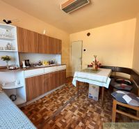 Innenraum eines Einfamilienhauses mit Esstisch, Holzboden-Dekor und klassischem Schrank.