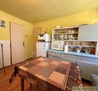 Eine Küche in einem Einfamilienhaus mit einem Holzboden und älteren Möbeln.