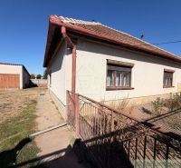 Ein Einfamilienhaus in Hurbanovo mit einem großen eingezäunten Garten, einer angrenzenden Garage und einem Rasenstück.