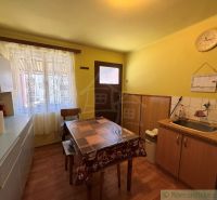 Küche in einem Einfamilienhaus mit Holzboden und gelben Wänden.