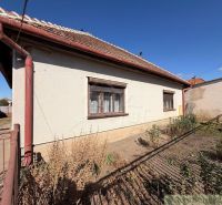 Ein Einfamilienhaus in Hurbanovo mit weißer Fassade, braunen Fensterläden und einem Garten hinter dem Haus.