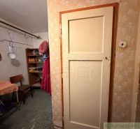 Interieur eines Einfamilienhauses mit Flur, Stuhl und Regalen. Hier hängen Küchenwerkzeuge.