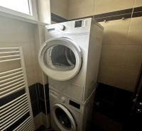Badezimmer in einer 2-Zimmer-Wohnung mit Waschmaschine und Trockner übereinander.