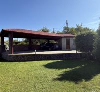 Ein Einfamilienhaus in Zlaté Moravce mit einem Pavillon, umgeben von gepflegtem Rasen und Bäumen.