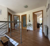 Flur mit Treppe und Holzboden in einem Einfamilienhaus.