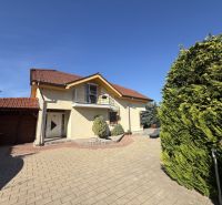 Ein Einfamilienhaus in Zlaté Moravce mit Zufahrtsstraße, Balkon und grünen Bäumen.