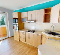 Küche in einer 3-Zimmer-Wohnung mit Holzboden und direktem Zugang zum Balkon.