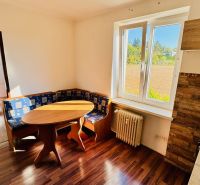 1-Zimmer-Wohnung mit Ecksofa und Boden in Holzoptik.