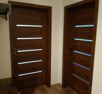 Zwei Holztüren und ein Boden mit Holzdekor in einer 2-Zimmer-Wohnung.