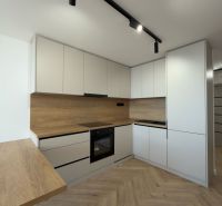 Küche in einer 4-Zimmer-Wohnung mit Holzboden und modernen Schränken.