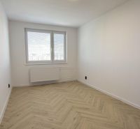 Ein Zimmer mit einem Holzboden-Dekor in einer 4-Zimmer-Wohnung, elegant erhellt durch ein großes Fenster.