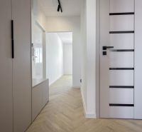 Der Flur in einer 4-Zimmer-Wohnung mit Boden und weißen Türen.