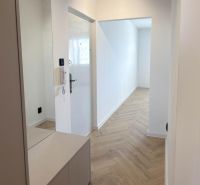 Flur mit Spiegel und Holzboden in einer 4-Zimmer-Wohnung.