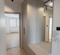 Flur in einer 4-Zimmer-Wohnung mit integriertem Stauraum und Boden mit Holzdekor.