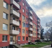 Mehrfamilienhaus mit Treppenhaus und Balkonen, mit Parkplätzen vor dem Gebäude, Blick auf das Einzimmerapartment.