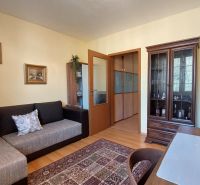 Wohnzimmer in einer 3-Zimmer-Wohnung mit Möbeln, Holzboden und Dekorationen.