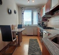 Küche in einer 3-Zimmer-Wohnung mit Esstisch und Boden in Holzoptik.
