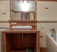 Badezimmer in einer 3-Zimmer-Wohnung mit Badewanne, Waschbecken und Waschmaschine.