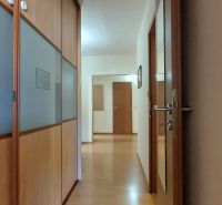 Der Flur in der 3-Zimmer-Wohnung mit Holzelementen und einem Einbauschrank.