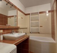 Badezimmer in einer 3-Zimmer-Wohnung mit Badewanne und Waschbecken, ergänzt durch Keramikfliesen.