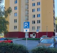 Wohngebäude im Viertel SNP in Trenčianske Teplice mit Parkplatz und Grünflächen im Vordergrund.