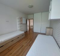 Ein Schlafzimmer in einer 3-Zimmer-Wohnung mit Holzboden, zwei Betten und einem Einbauschrank.