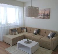 Wohnzimmer in einer 3-Zimmer-Wohnung mit Ecksofa und Holzboden.