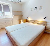 Helles Schlafzimmer in einer 2-Zimmer-Wohnung mit Holzboden und Doppelbett.