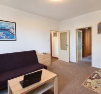 Wohnzimmer in einer 3-Zimmer-Wohnung mit Sofa, Couchtisch und Bildern an der Wand.