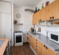 Küche in einer 3-Zimmer-Wohnung mit Küchenzeile, Geräten und Bodenbelag in Holzoptik.