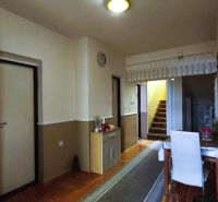 Flur in einem Einfamilienhaus mit Teppichtreppe, Tisch und Boden mit Holzdekor.