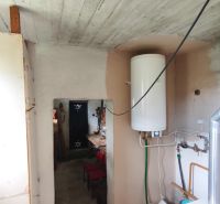 Badezimmer im Einfamilienhaus mit Boiler und Heizraum, Fliesen auf dem Boden.