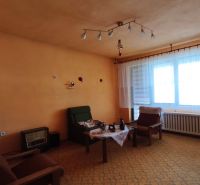 Wohnzimmer in einem Einfamilienhaus mit orangefarbenen Wänden und Vintage-Möbeln.