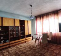 Wohnzimmer in einem Einfamilienhaus mit Vitrine, Esstisch und Fernseher.