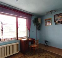 Blaues Zimmer mit Fenster, Tisch und Stuhl in einem Einfamilienhaus.