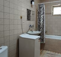 Badezimmer mit Badewanne, Waschbecken und Waschmaschine in einem Einfamilienhaus.