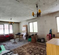 Innenraum eines Einfamilienhauses mit Kunststofffenstern, Ziegelwand und dekorativem Teppich.