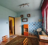 Ein Zimmer in einem Einfamilienhaus mit Fliesen, einem Holzboden und einem großen Fenster.