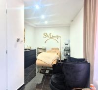 Innenhandelsräume mit Sitzgarnitur, Spiegel und goldenen Accessoires.