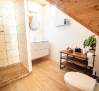 Badezimmer mit Holzboden, Dusche und Waschbecken. Hotels und Pensionen.
