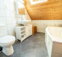 Badezimmer mit Badewanne, Waschbecken und Fliesen in Hotels und Pensionen.