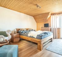 Ein Hotelzimmer mit einem Bett, einem Sessel, einem Teppich und einem Boden mit Holzdekor.