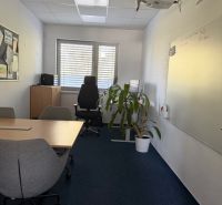 Innenraum eines Büros mit einem Whiteboard, einem Konferenztisch und einem Projektor an der Wand des Gebäudes.