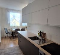 Küche in einer 3-Zimmer-Wohnung, mit Holzboden und Essecke.