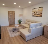 Wohnzimmer in einer 3-Zimmer-Wohnung mit Holzboden und bequemer Couch.