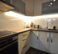 Küche in einer 3-Zimmer-Wohnung mit einer linearen Küchenzeile und einem Boden in Holzoptik.