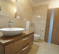 Badezimmer in einer 3-Zimmer-Wohnung mit Waschbecken, Holzboden und Toilette.