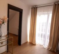 Innenraum eines Einfamilienhauses mit einem dekorativen Tisch und Auszeichnungen eines Immobilienbüros.